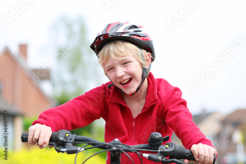 Portrait of happy school boy on his bike