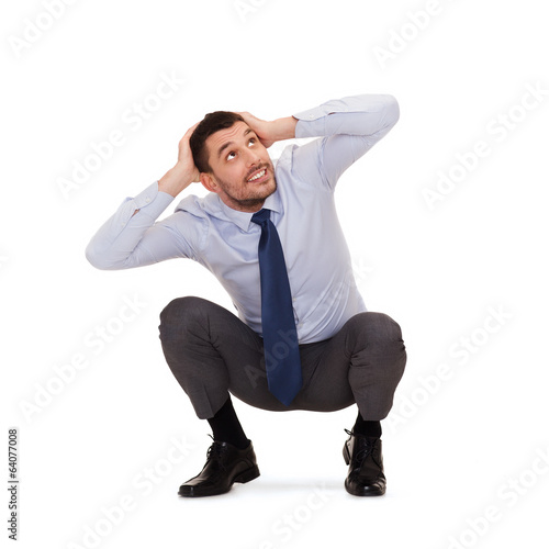 smiling businessman crouching on the floor
