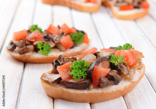 Delicious bruschetta with mushrooms on table close-up