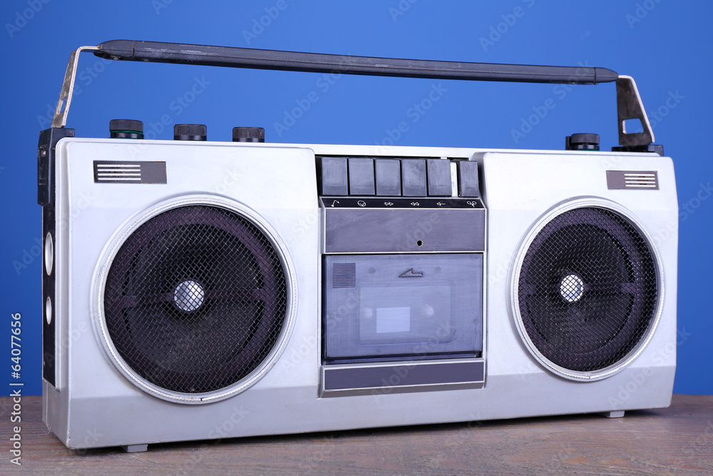 Retro cassette stereo recorder on table on blue background Retro cassette stereo recorder on table on blue background