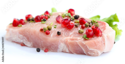 Raw meat steak with leaf lettuce, spices and pomegranate seeds,