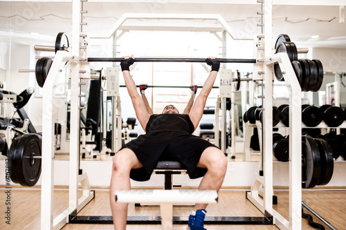 bodybuilder training in the gym: chest - barbell bench press