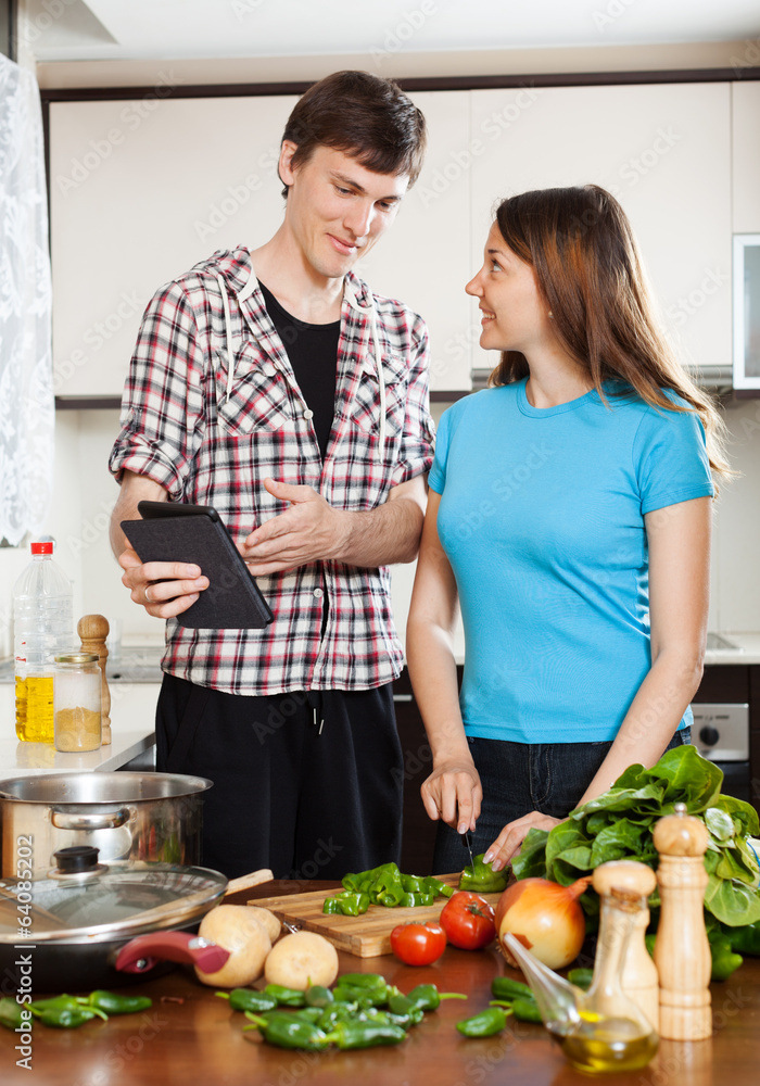 couple cooking with eBook