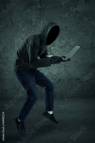 Thief stealing a laptop computer photo