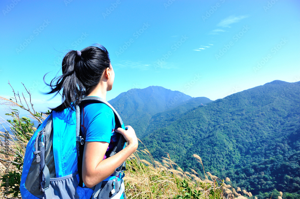 hiking woman enjoy the beautiful view at mountain peak 