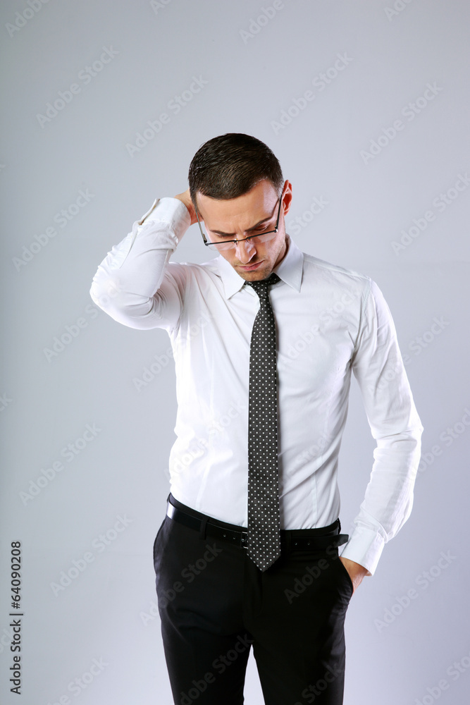 Portrait of a pensive businessman in glasses on gray background Portrait of a pensive businessman in glasses on gray background