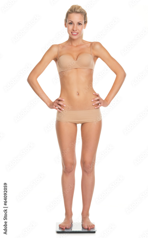 Full length portrait of happy young woman in lingerie standing s