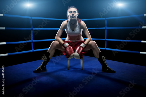 Boxing woman sitting in the boxing arena,by blue lights