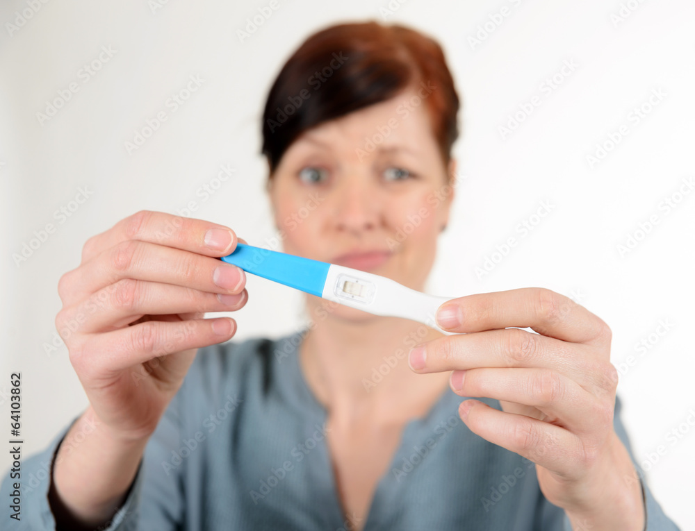 Enttäuschte Frau mit Schwangerschaftstest