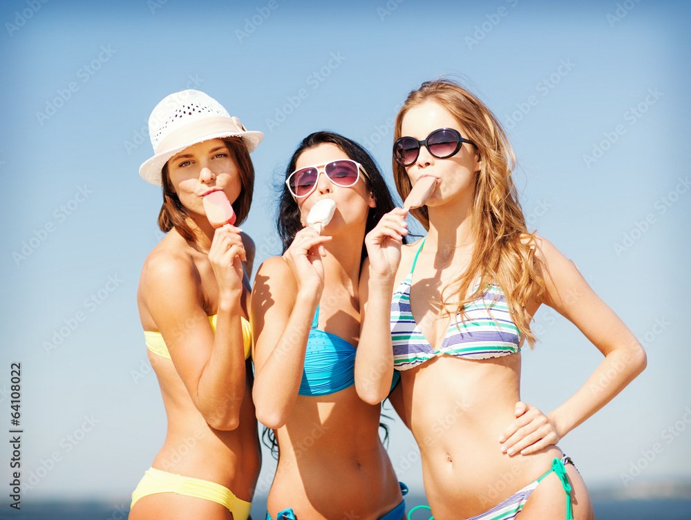 girls in bikinis with ice cream on the beach