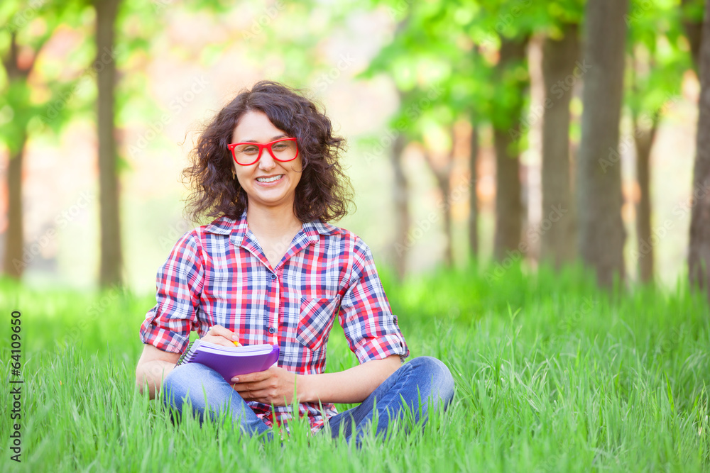 Indian girl with notebook in the park. Indian girl with notebook in the park.