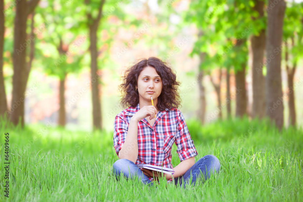 Indian girl with notebook in the park. Indian girl with notebook in the park.