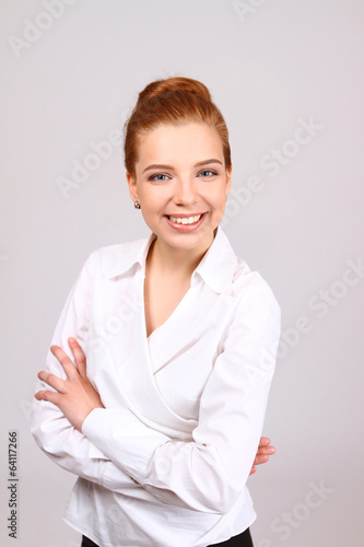 Business woman smiling isolated over a gray background