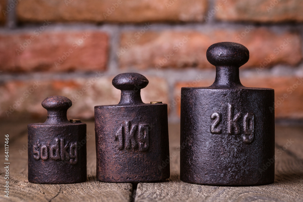 Vintage iron weights in front of an old brick wall.