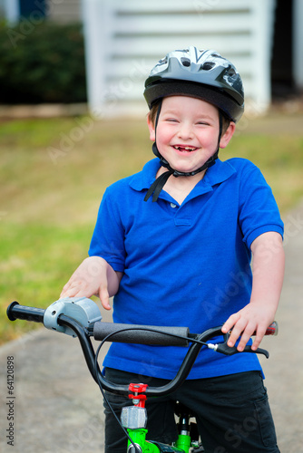 Happy child riding his bike outside his home