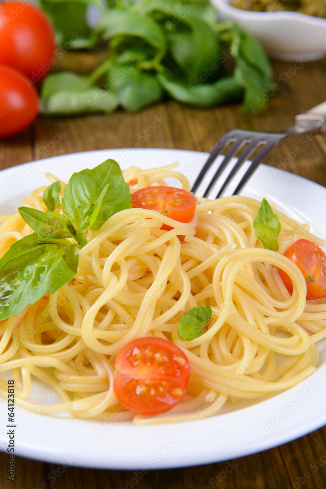 Delicious spaghetti with tomatoes on plate on table close-up Delicious spaghetti with tomatoes on plate on table close-up