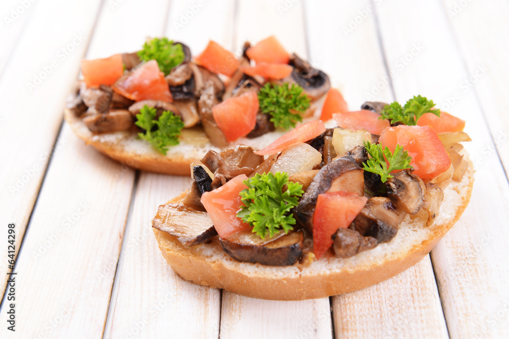 Delicious bruschetta with mushrooms on table close-up