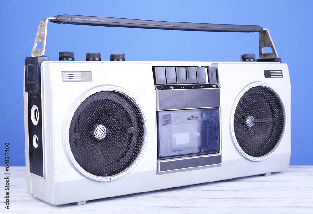 Retro cassette stereo recorder on table on blue background Retro cassette stereo recorder on table on blue background