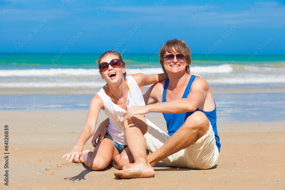 front view happy young couple sitting on beach front view happy young couple sitting on beach