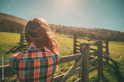 Young woman by a fence on a ranch photo