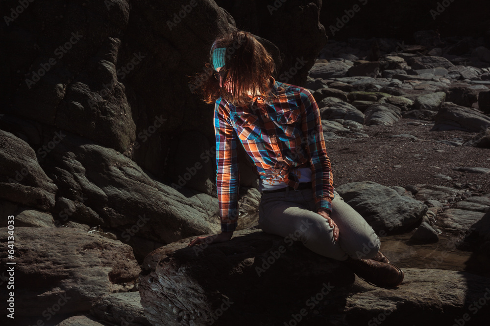 Naklejka premium Woman sitting on a rock