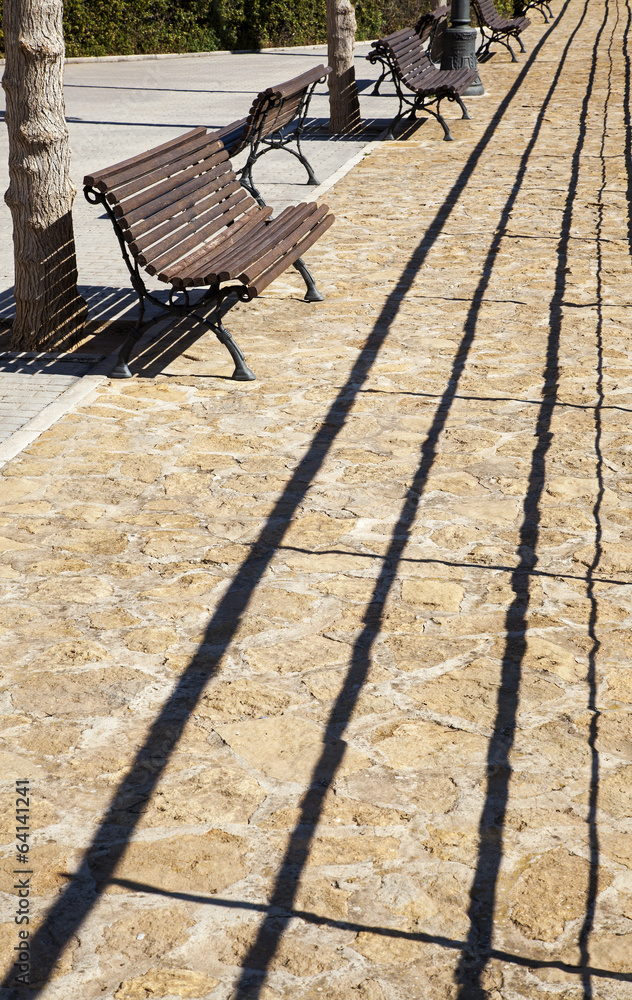 Bench in Mediterranean public park, with paved stones. Bench in Mediterranean public park, with paved stones.