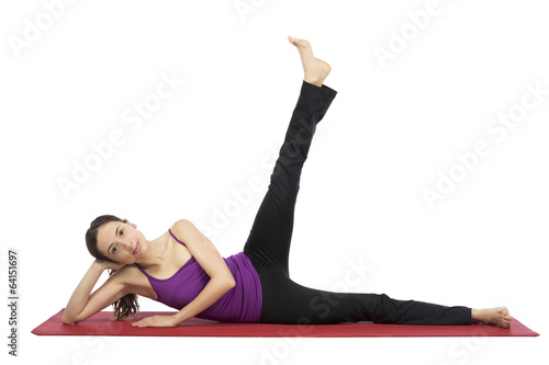 Young woman doing leg raising during workout
