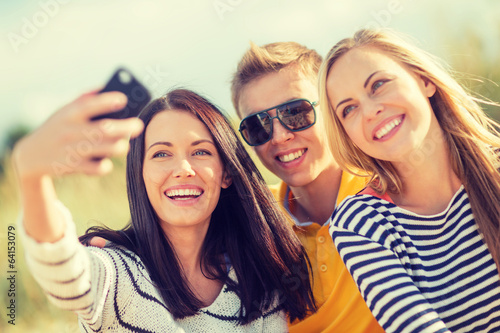 group of friends taking picture with smartphone