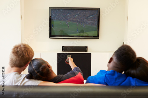 Two Young Couples Watching Television At Home Together