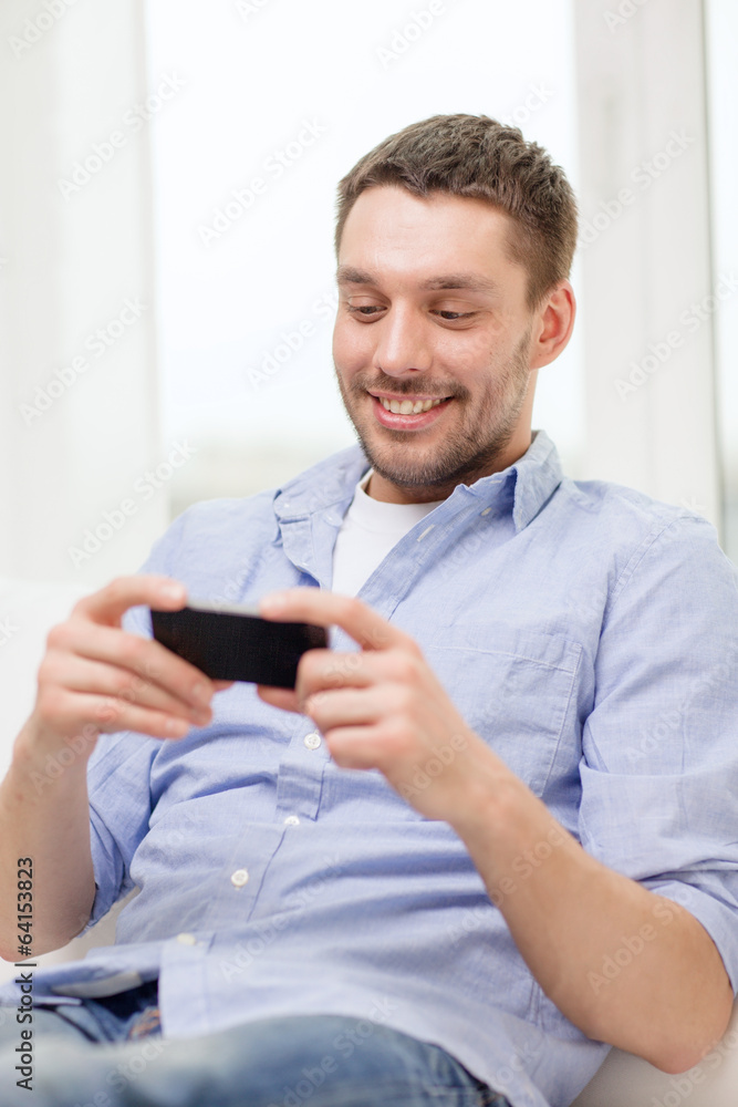 smiling man with smartphone at home smiling man with smartphone at home