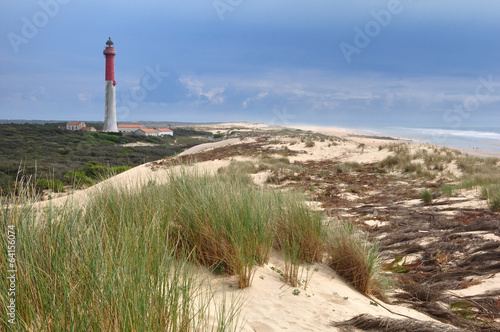 Phare blanc et rouge dans les dunes domine la mer