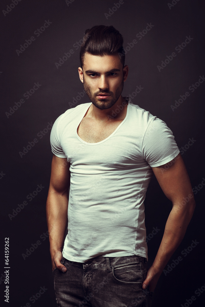 Photo & Art Print Handsome man posing in studio on dark background