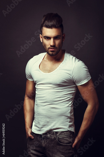 Fototapet Handsome man posing in studio on dark background