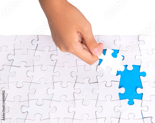 Young girl hand playing jigsaw puzzle