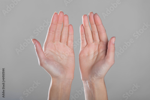 Open hands on gray background