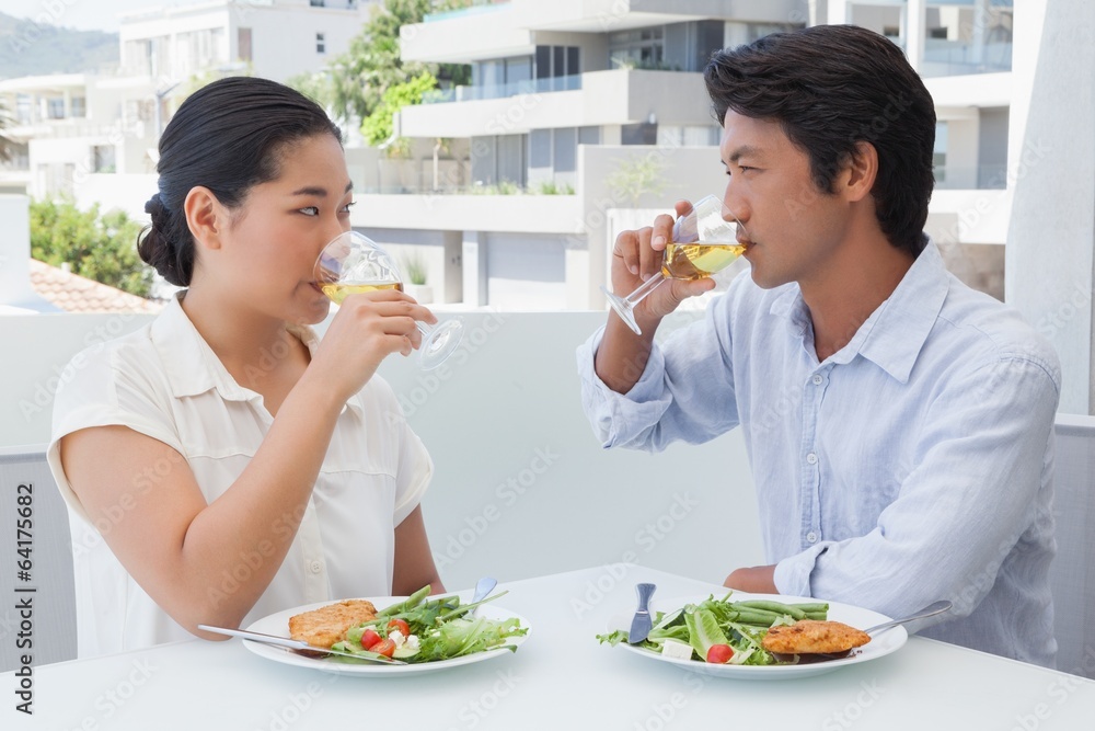 Happy couple having a meal together with white wine Happy couple having a meal together with white wine