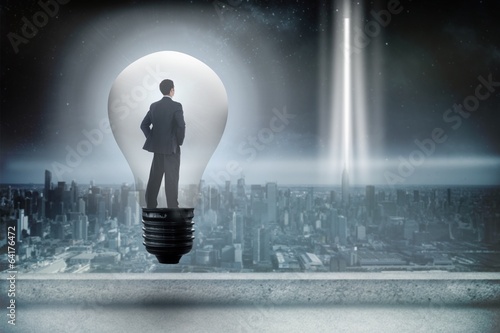 Composite image of thinking businessman in light bulb