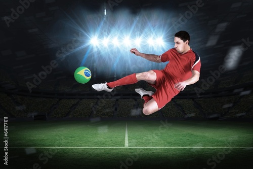 Composite image of fit football player jumping and kicking