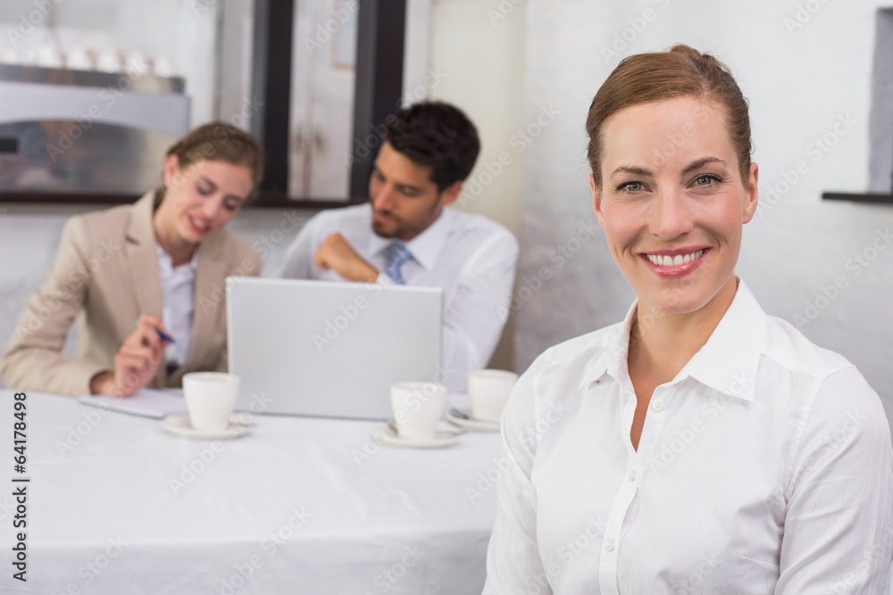 Businesswoman with colleagues in meeting at office desk Businesswoman with colleagues in meeting at office desk