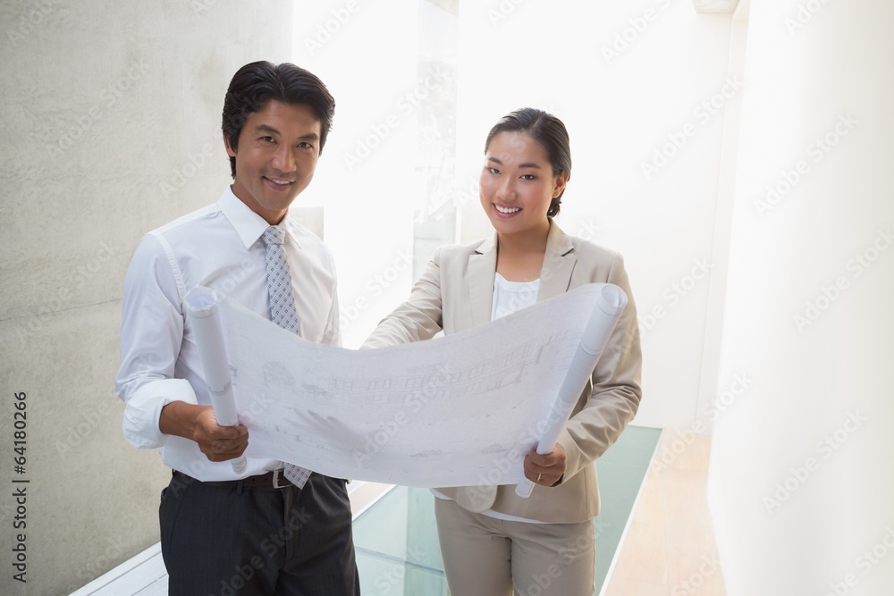 Estate agent looking at blueprint with potential buyer Estate agent looking at blueprint with potential buyer