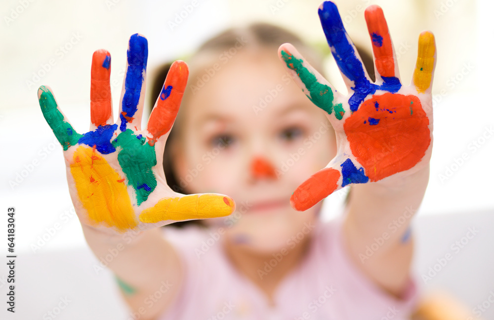 Fototapeta premium Portrait of a cute girl playing with paints