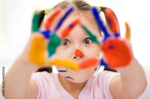 Portrait of a cute girl playing with paints
