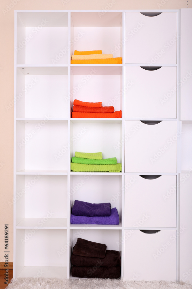 White shelves with colored towels close up White shelves with colored towels close up