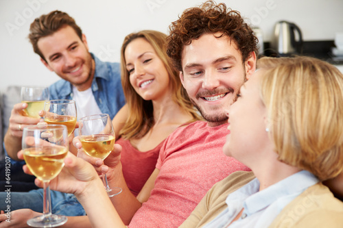 Group Of Friends Enjoying Glass Of Wine At Home
