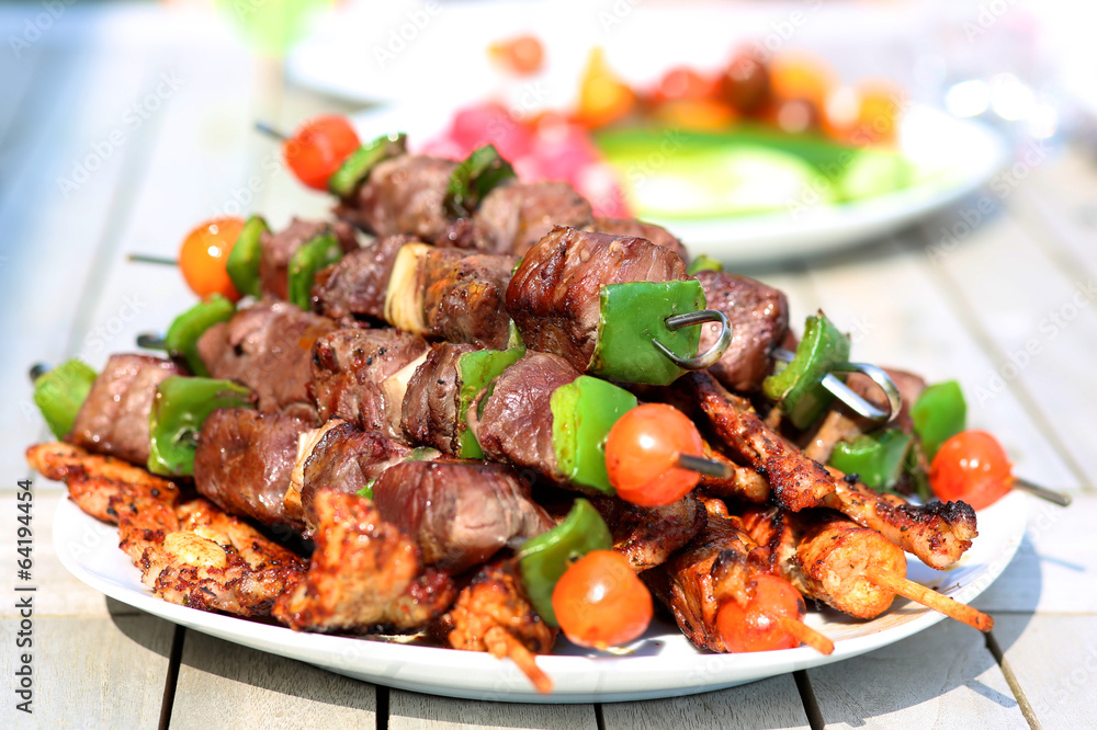 Assorted delicious grilled meat with vegetableы on white plate Assorted delicious grilled meat with vegetableы on white plate