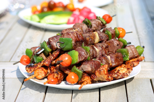 Assorted delicious grilled meat with vegetableы on white plate 