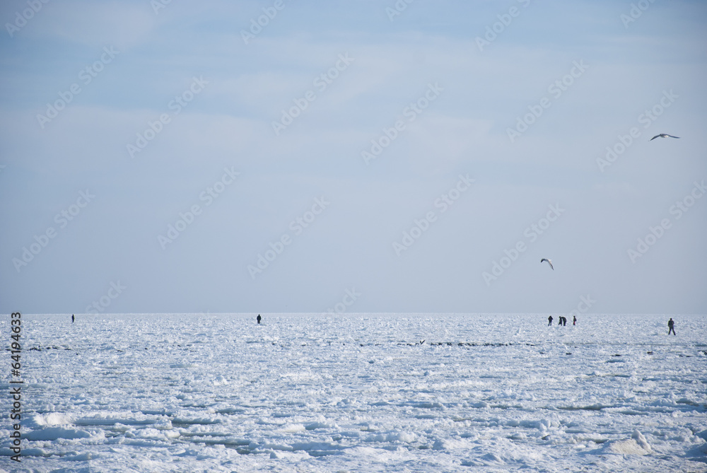 people walk on a frozen sea