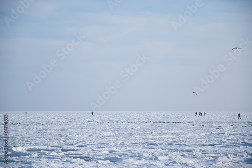 people walk on a frozen sea