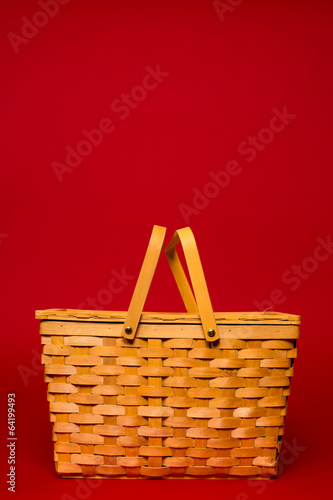 Wicker picnic basket on a red background