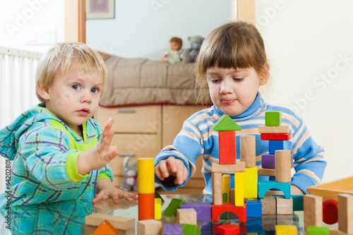  siblings  playing with wooden toys